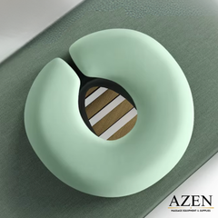Light green neck pillow on a gray surface, branded 'AZEN'.