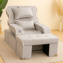Gray armchair with a pillow on a light wooden floor.