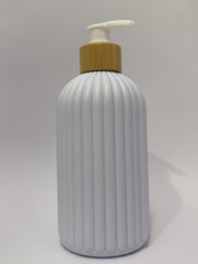 A ribbed white plastic bottle with a gold-colored collar and a white pump dispenser, shown against a plain white background.